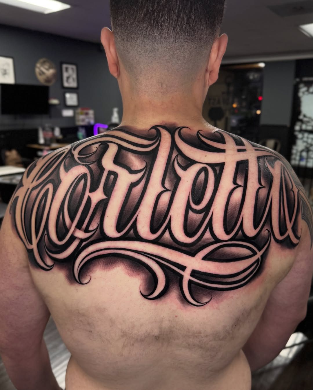 Custom script tattoo, upper back